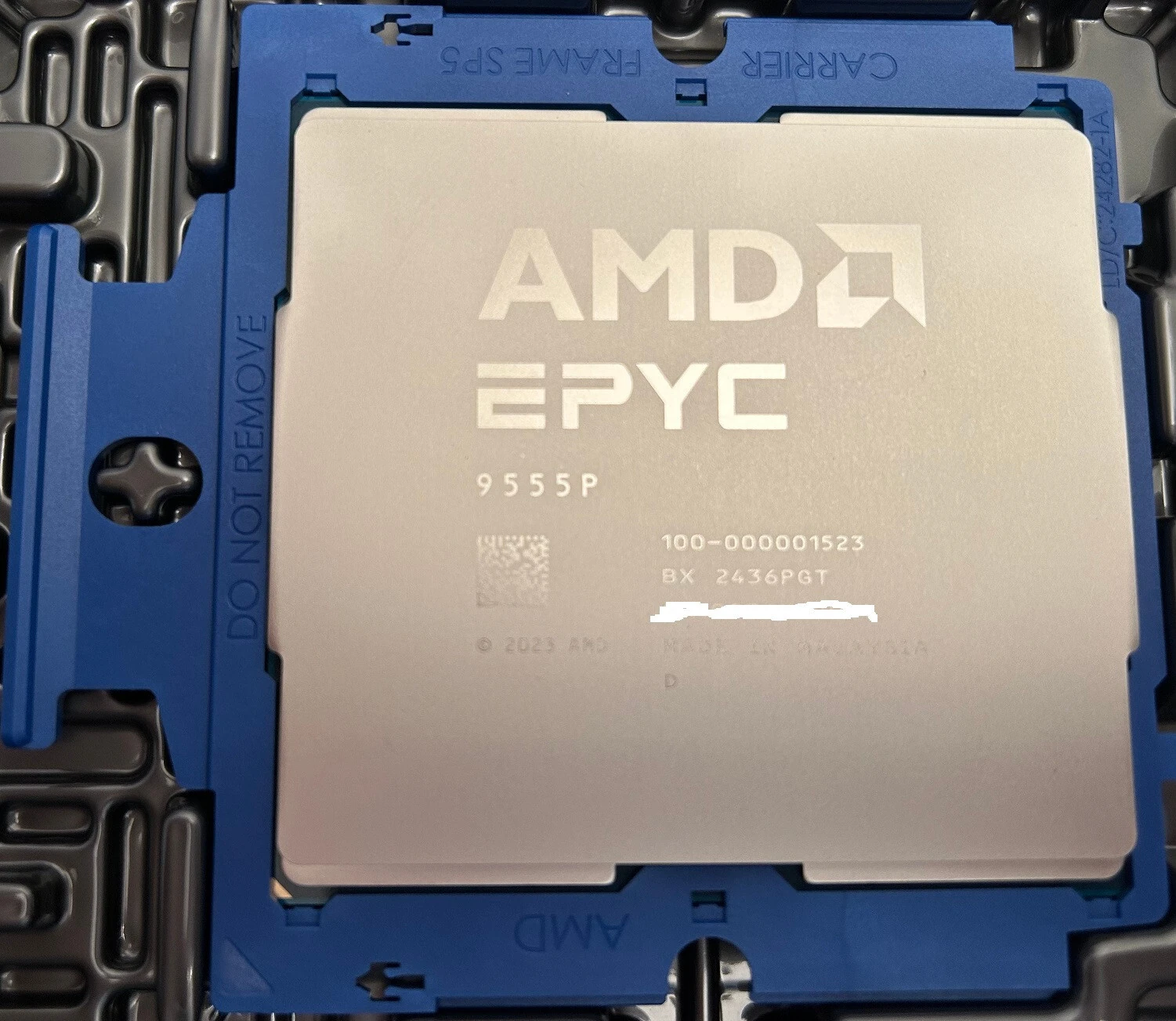 AMD EPYC 9555P с маркировкой 100-000001523 в держателе сокета SP5